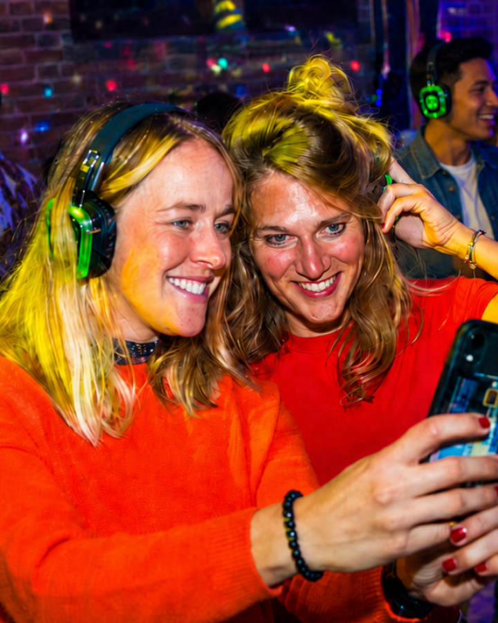 Twee reisgenoten maken een selfie tijdens de silent disco.