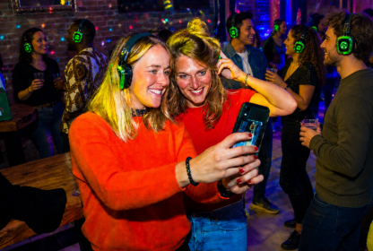 Twee reisgenoten maken een selfie tijdens de silent disco.