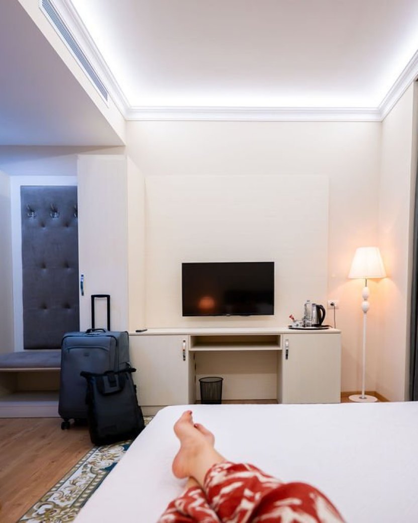 Moderne hotelkamer met tweepersoonsbed, televisie en zitruimte.