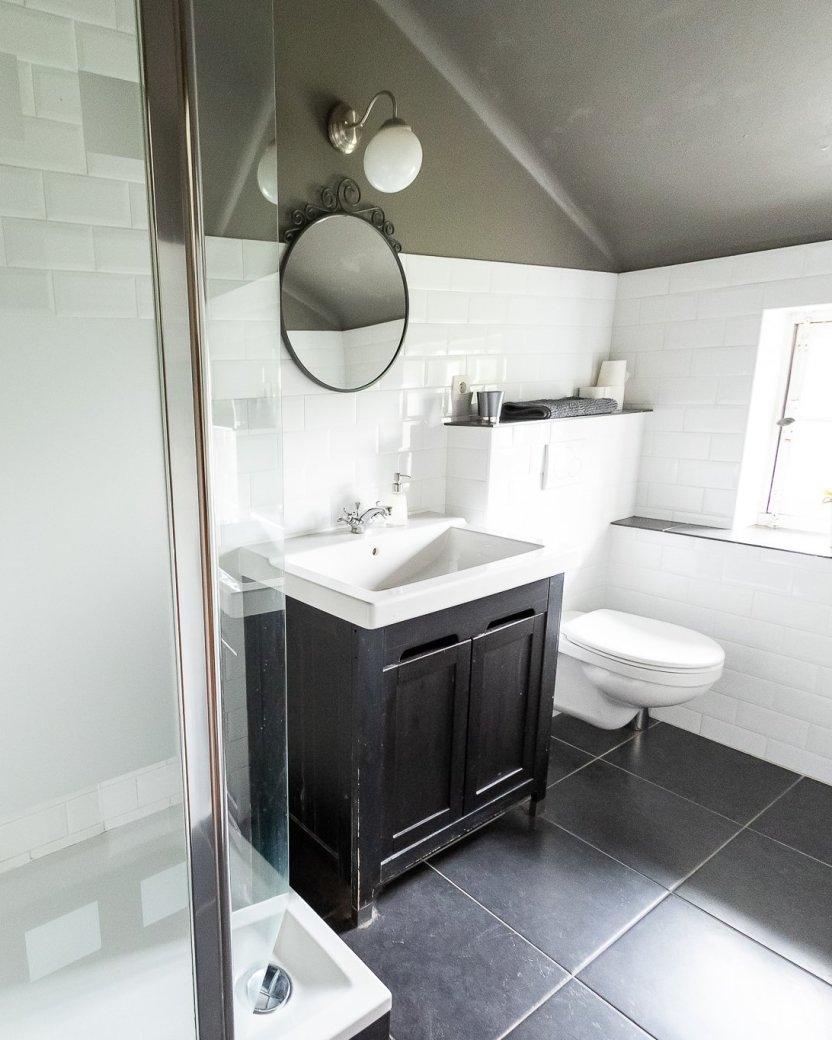 Badkamer met douche, wastafel en toilet in het landhuis.