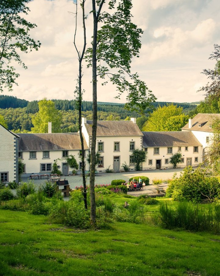 Domaine des Officiers in Vielsalm, omringd door groen en de heuvels van de Ardennen.