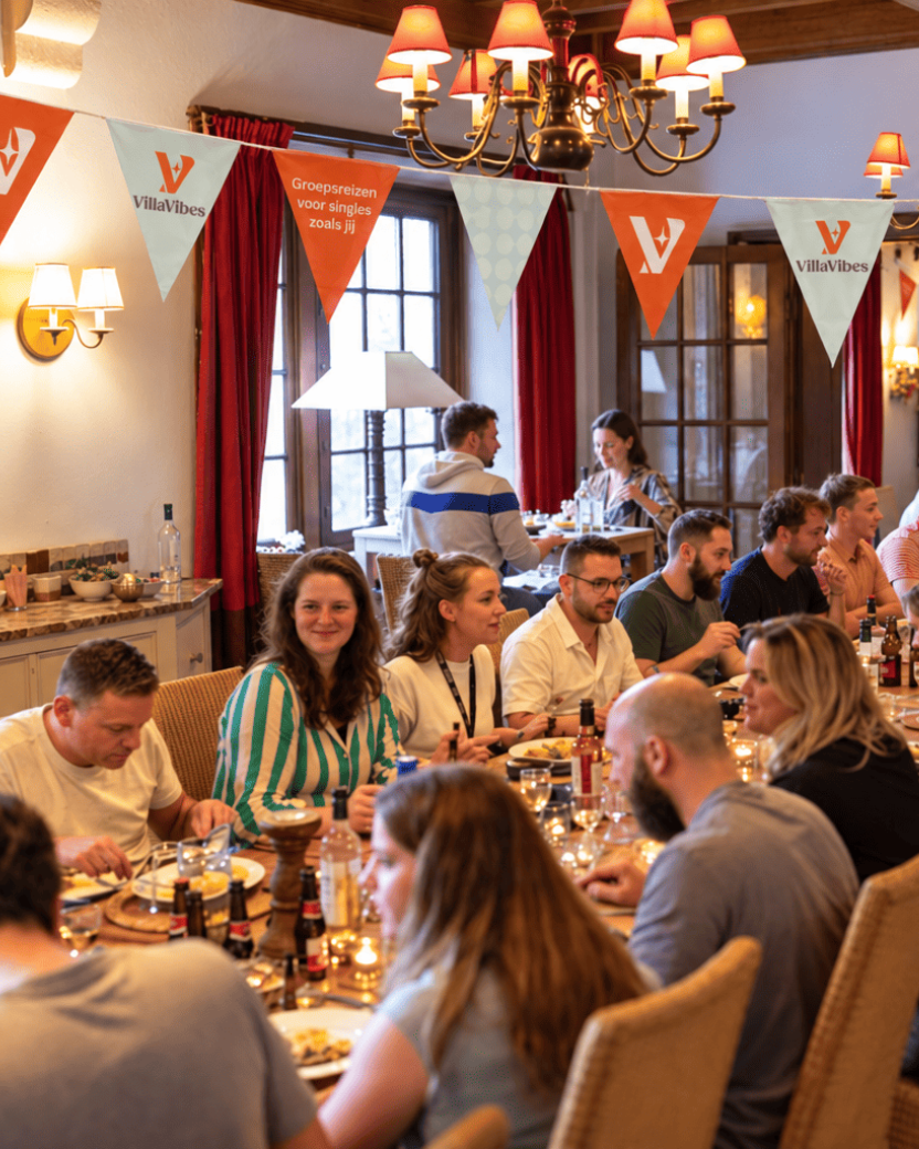 Reisgenoten dineren aan een lange tafel in de lodge.