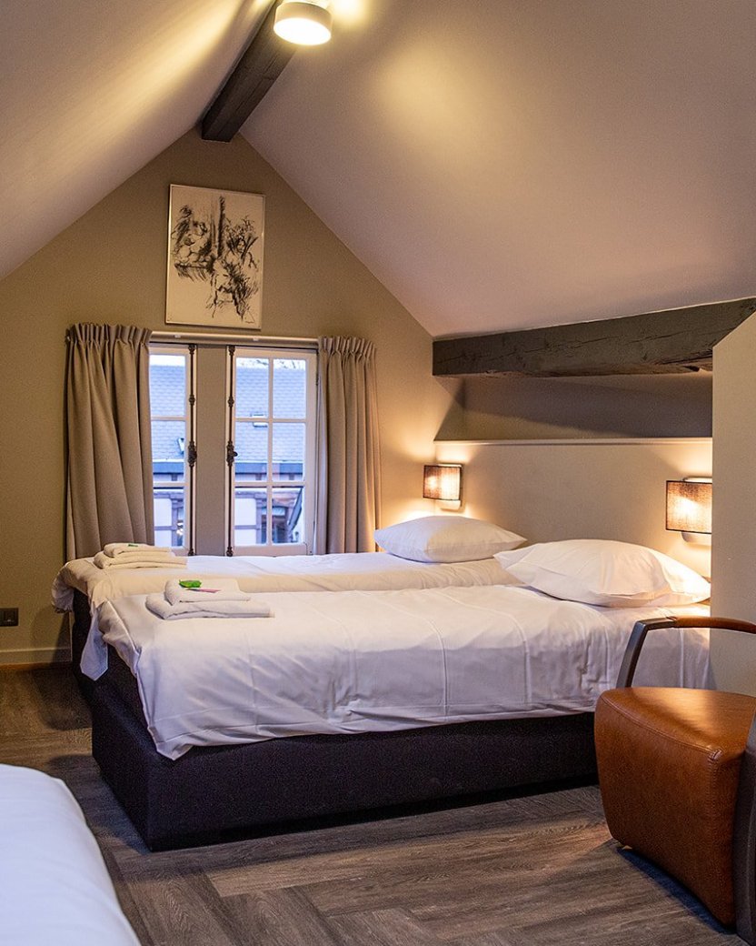 Ruime slaapkamer met aparte bedden.