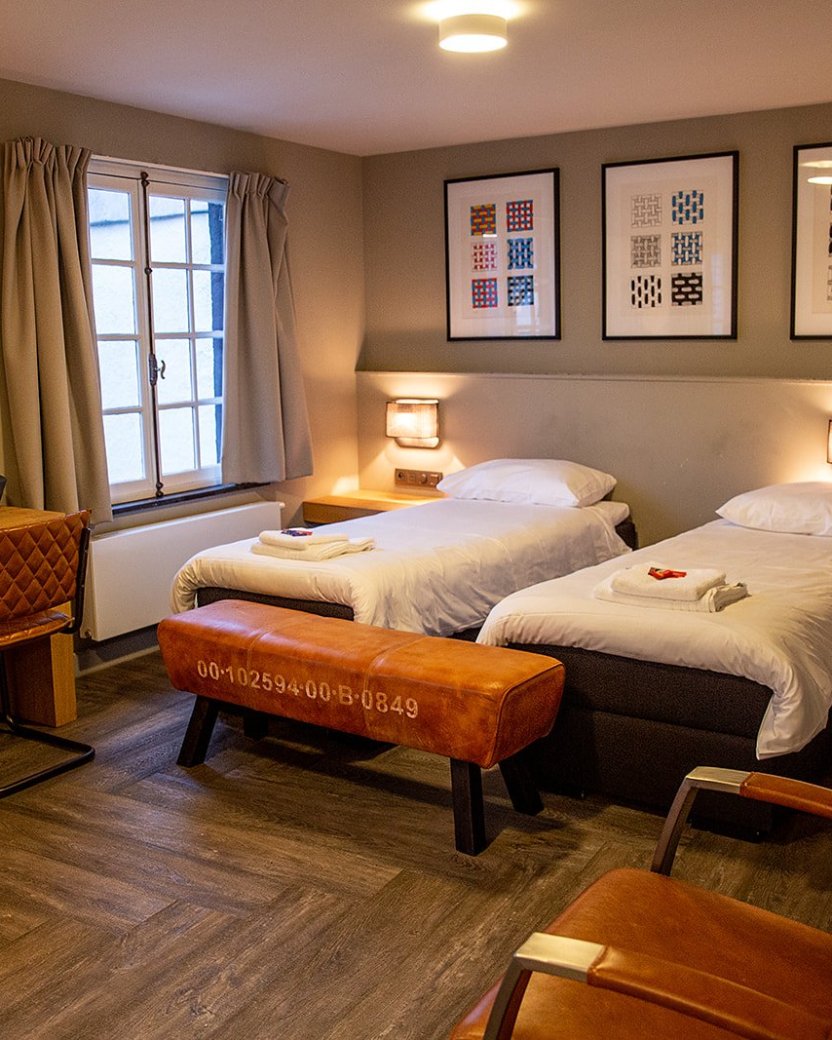 Slaapkamer met aparte bedden en zithoek.