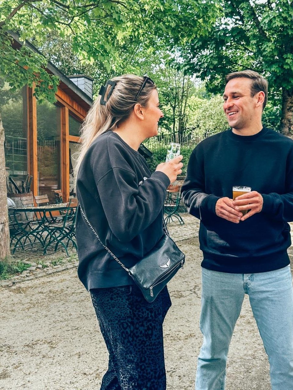 Twee reisgenoten kletsen met een drankje in de hand.