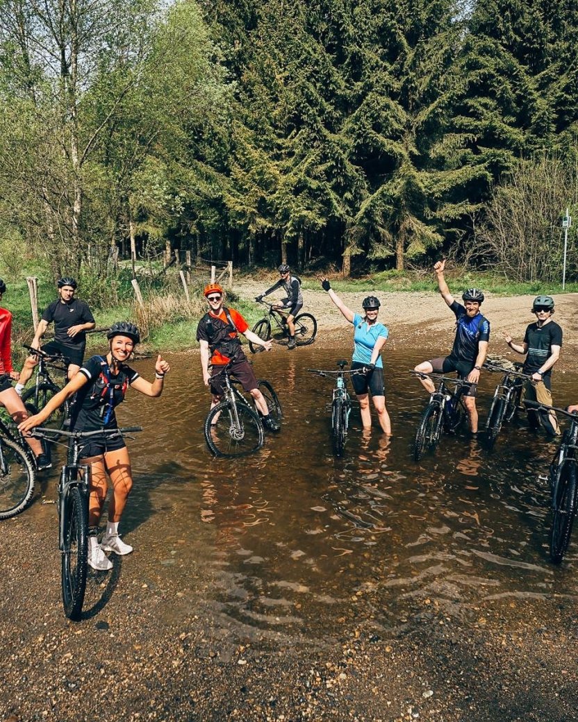 Groep mountainbikers poseert samen met hun fietsen tijdens een tocht door de Ardennen.