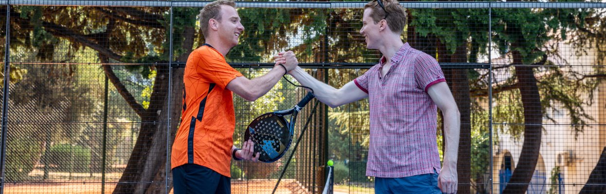 Padellers feliciteren elkaar op de padelbaan.