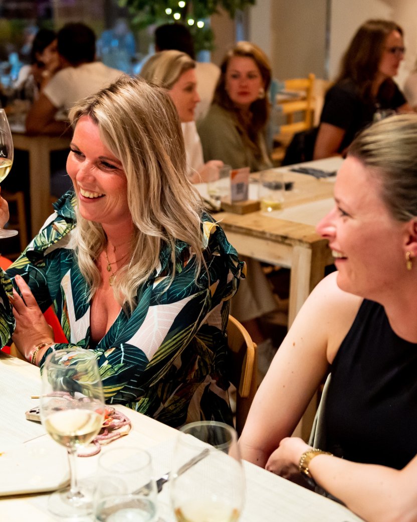 Groep reisgenoten geniet van een drankje tijdens het diner.