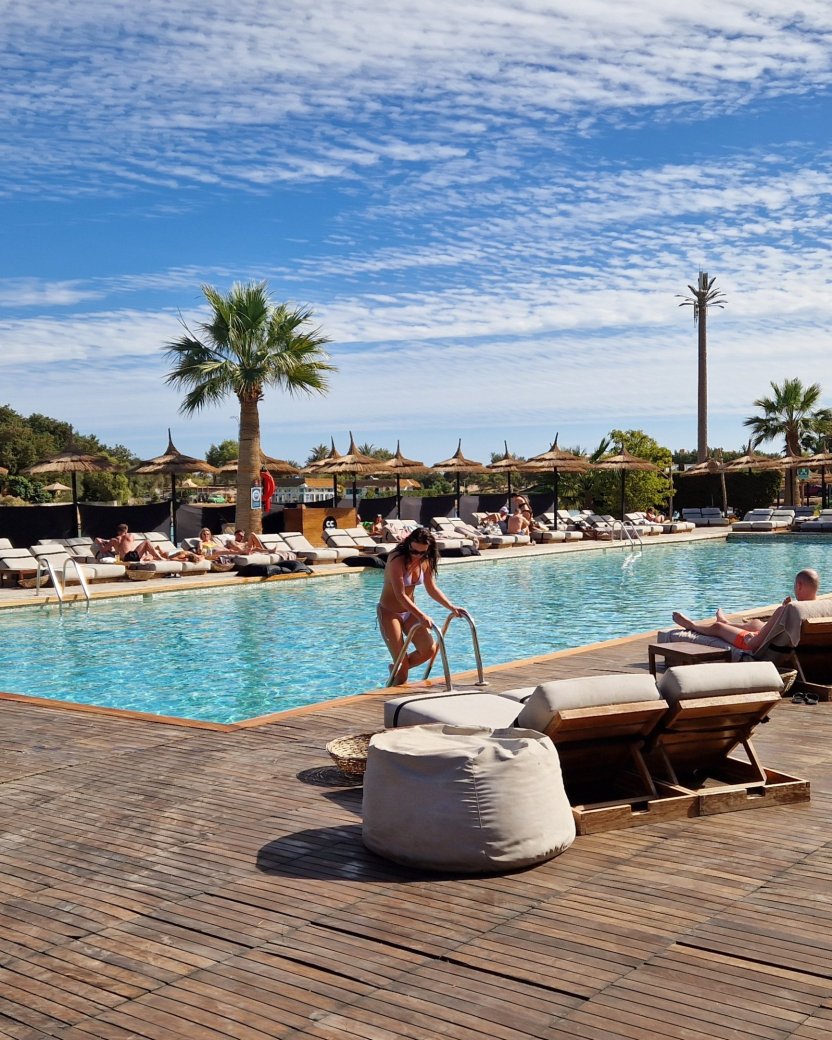 Zwembad met ligbedden en rieten parasols bij een zonnig resort in El Gouna.