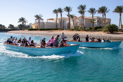 Reisgenoten varen in boten op het helderblauwe water in Egypte.
