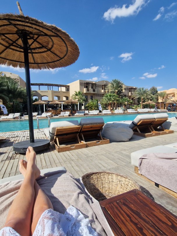 Ligbedden en rieten parasols bij het zwembad van een resort in El Gouna.