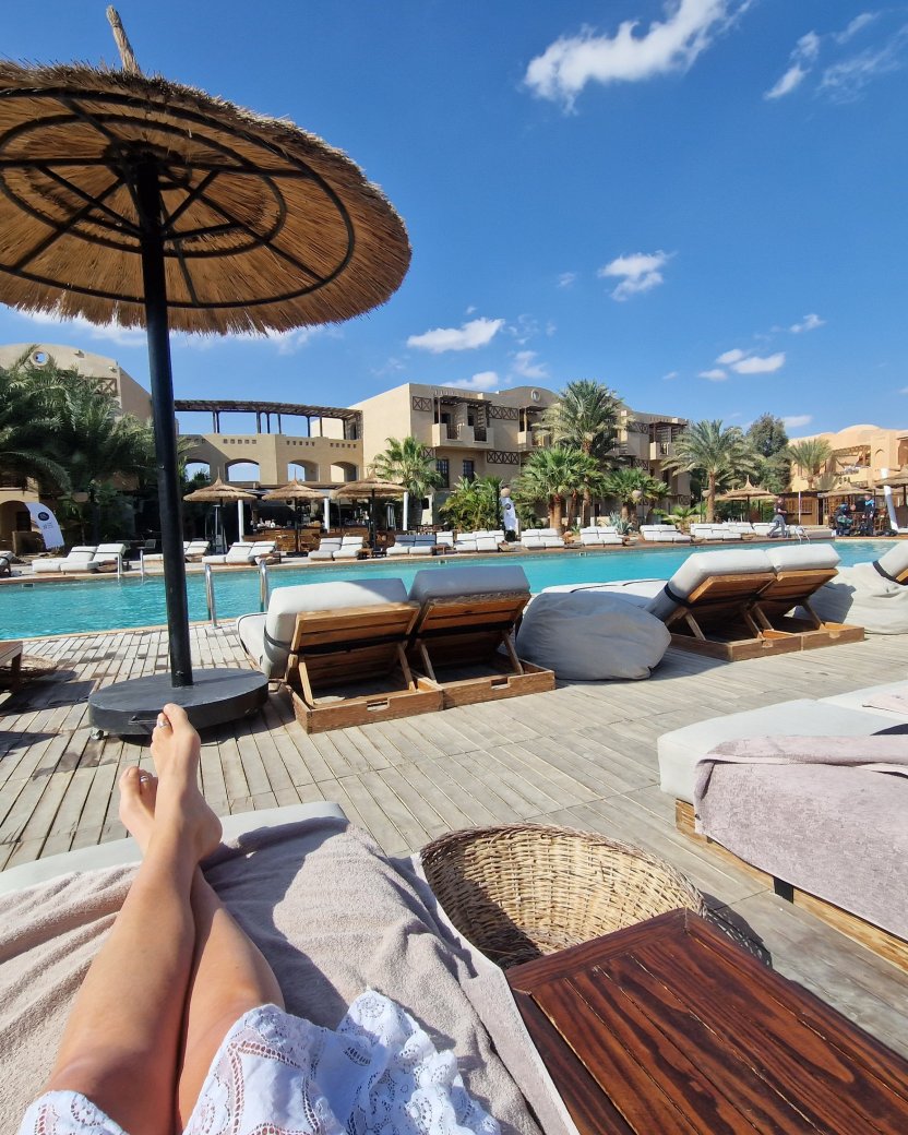 Ligbedden en rieten parasols bij het zwembad van een resort in El Gouna.