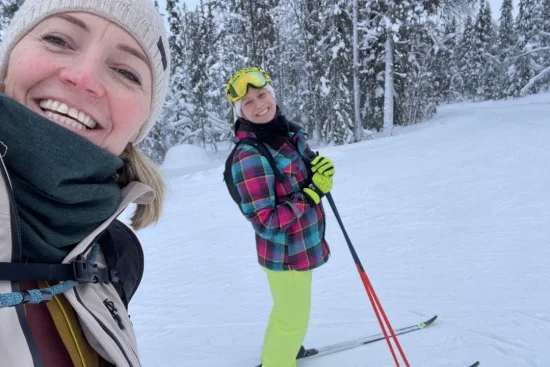 Reisgenoten maken samen een foto tijdens het langlaufen in het besneeuwde bos.