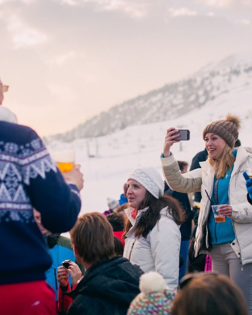 Wintersporters genieten samen van een drankje tijdens de après-ski in de sneeuw.