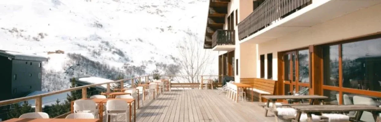 Zonnig terras van het wintersporthotel met uitzicht op de besneeuwde bergen.