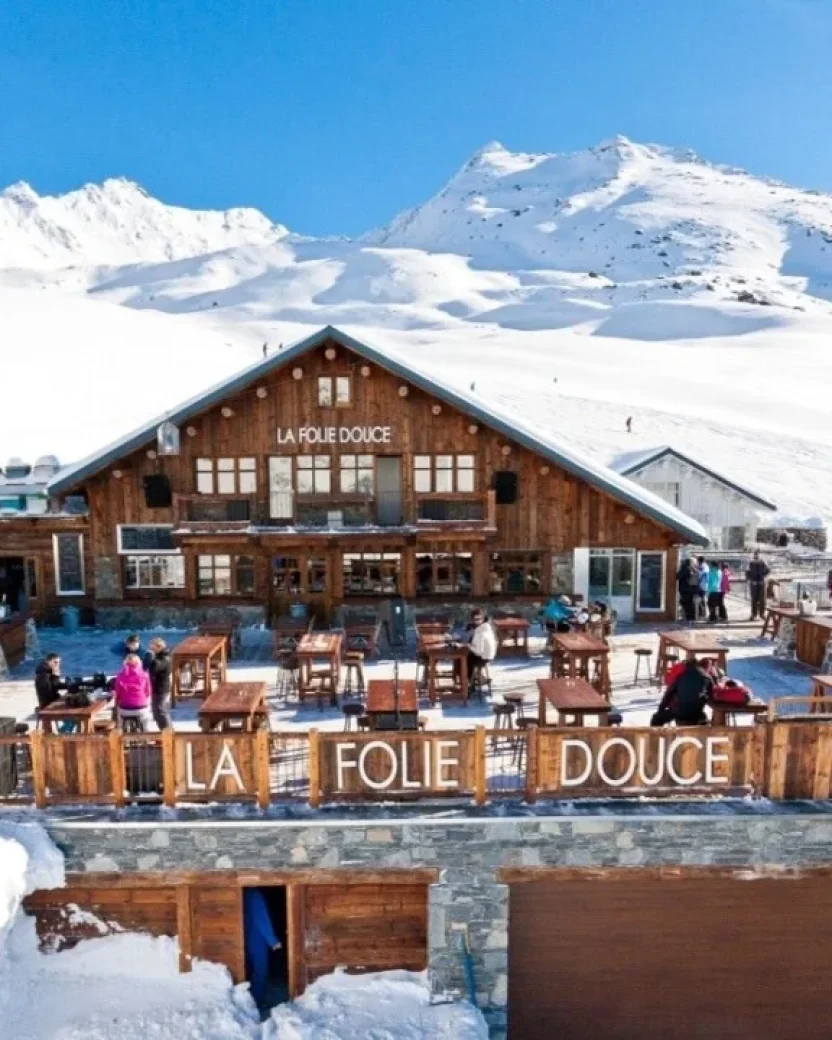 Berghut La Folie Douce met zonnig terras direct aan de besneeuwde piste.