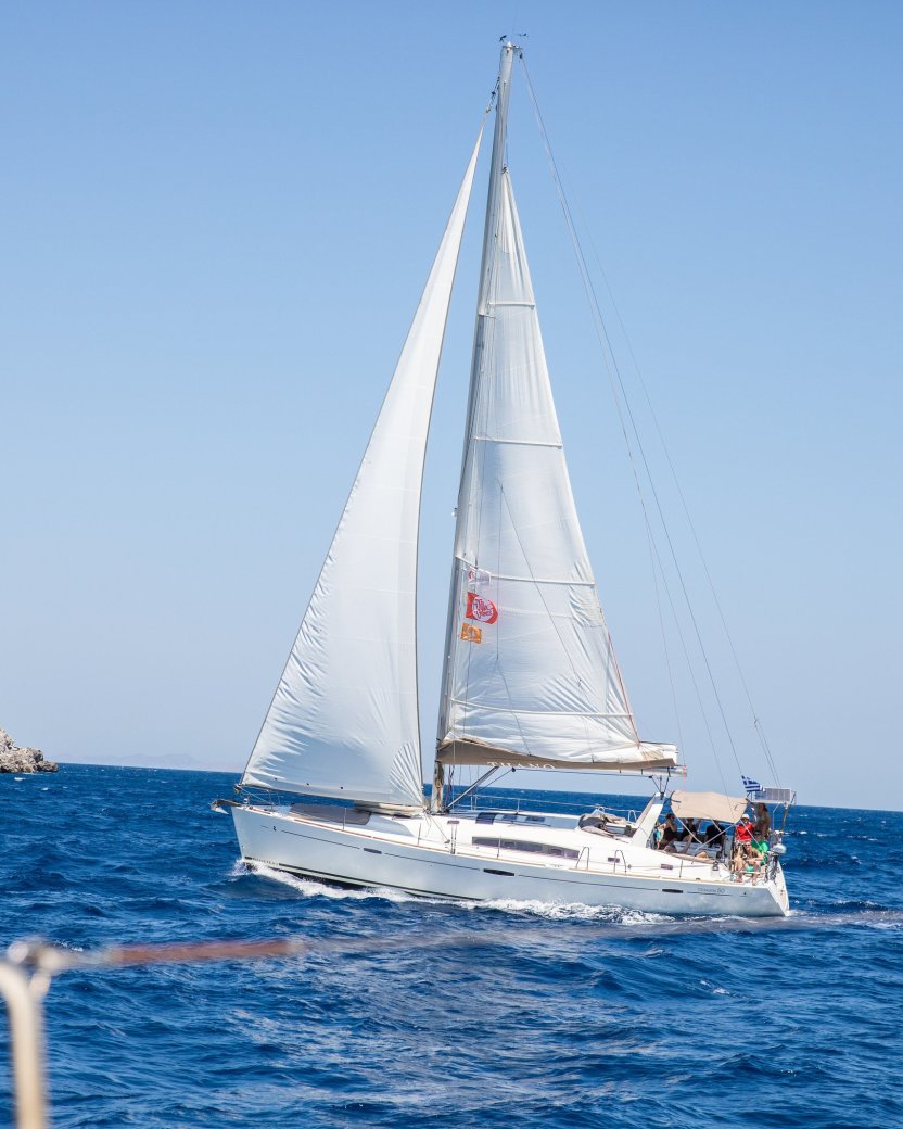 De zeilboot kantelt op het helderblauwe water.