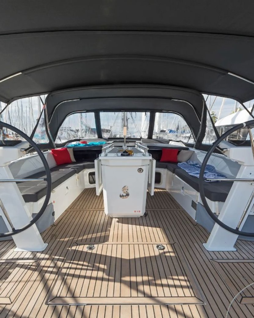 Ruime kuip van een zeilboot met twee stuurstanden en comfortabele zitbanken.