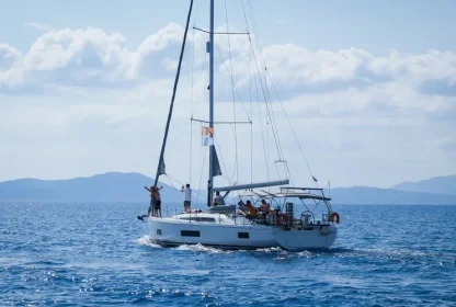 Reisgenoten genieten van het uitzicht vanaf de zeilboot terwijl zij varen op het helderblauwe water.