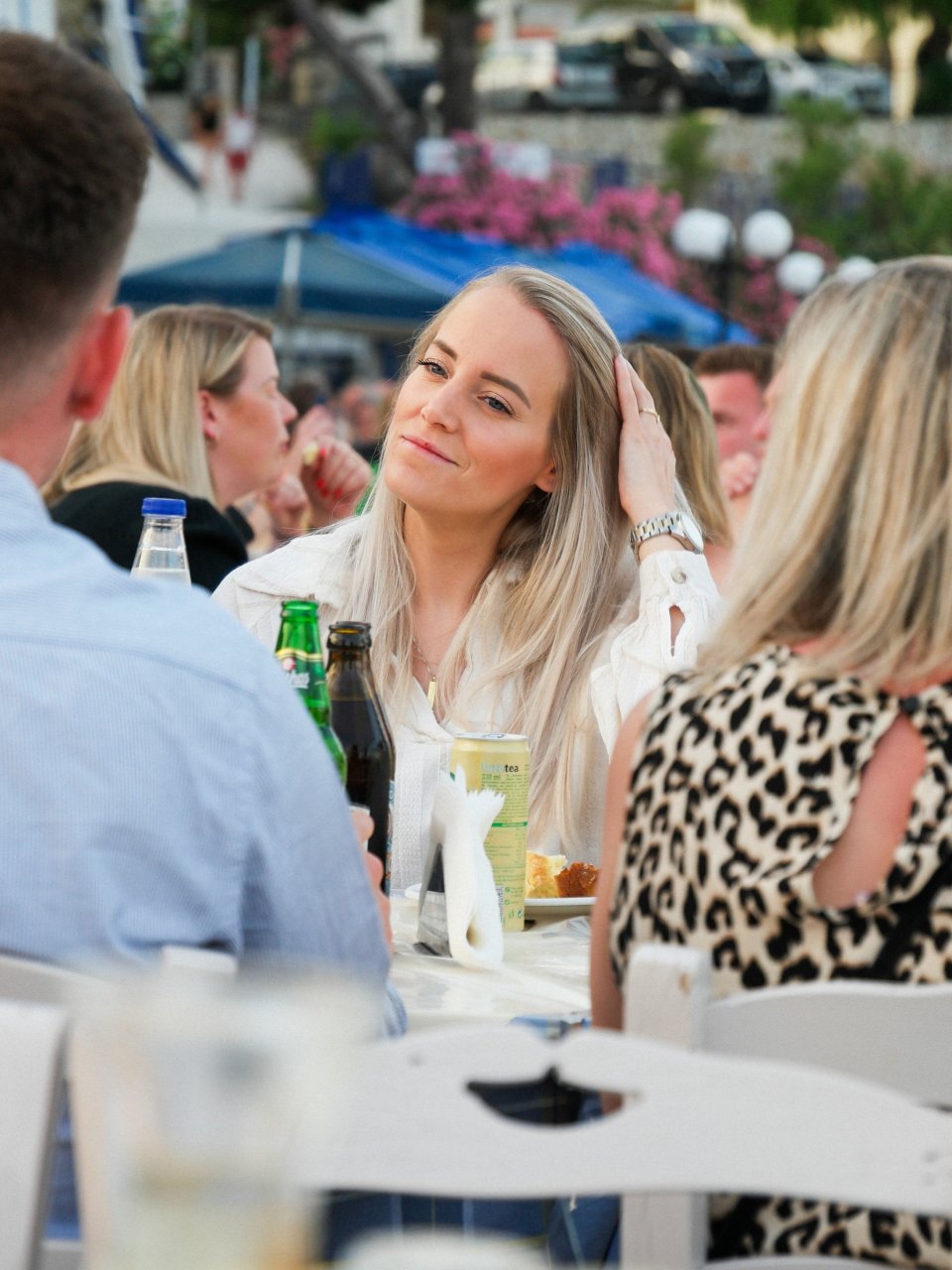 Reisgenoot zit ontspannen aan tafel tijdens een gezamenlijk diner op het terras.