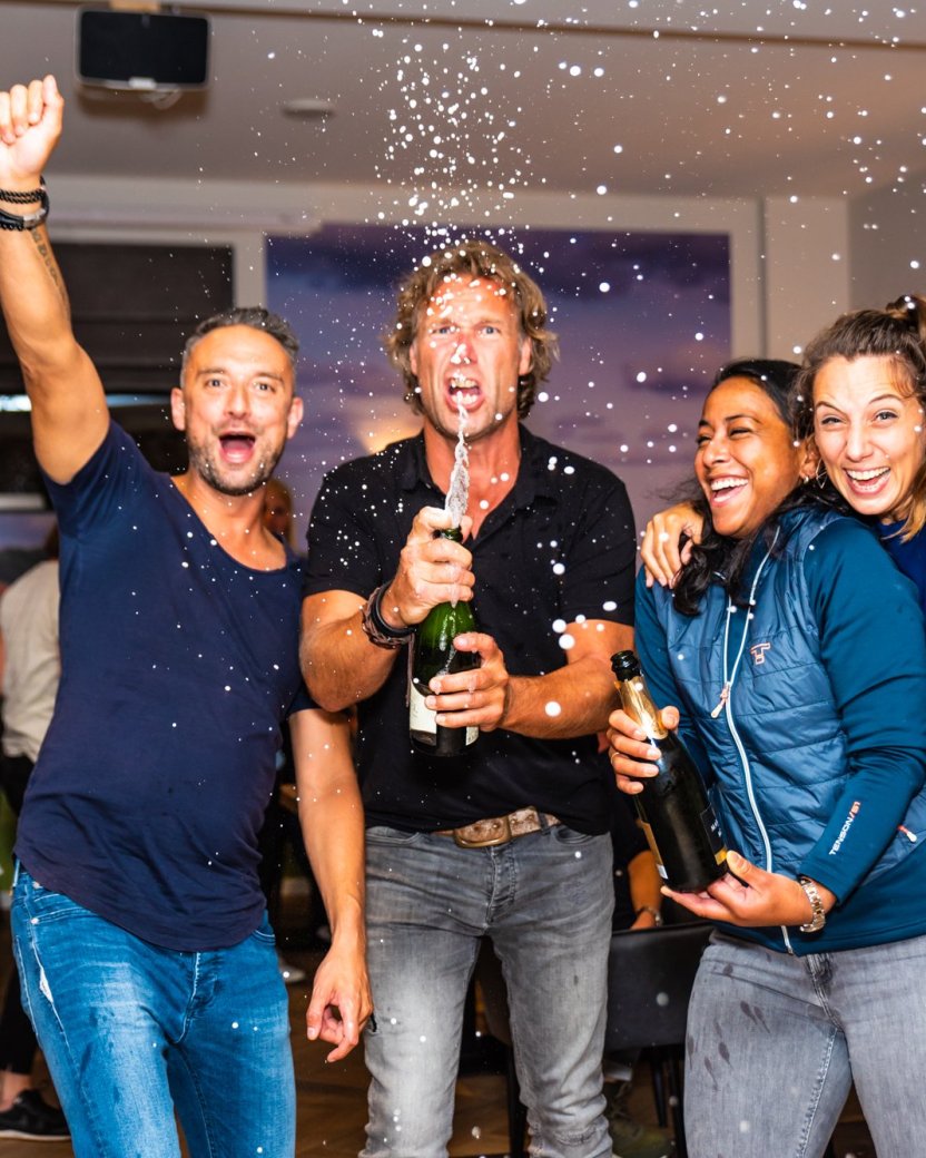 Vier reisgenoten vieren samen met bubbels tijdens een feestelijke avond.