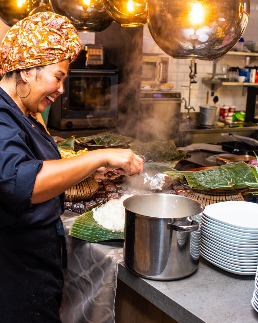 Kok bereidt een maaltijd in de keuken met verse ingrediënten.