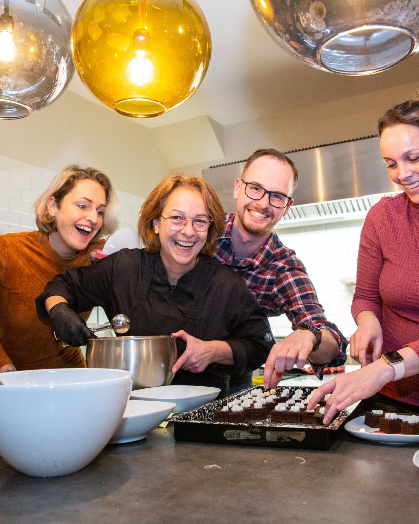 Reisgenoten en chef lachen met elkaar tijdens het koken.
