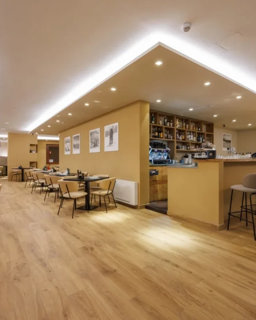 Moderne hotelbar met zitgedeelte en tafels voor gezamenlijke momenten.