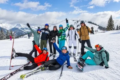 Groep wintersporters poseert voor de foto op de besneeuwde piste.