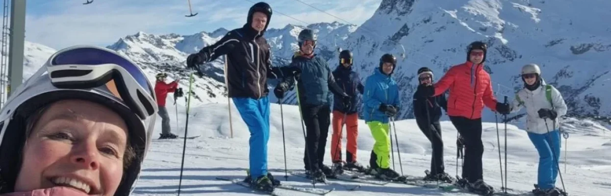 Wintersporters maken een selfie in de zon op de piste.