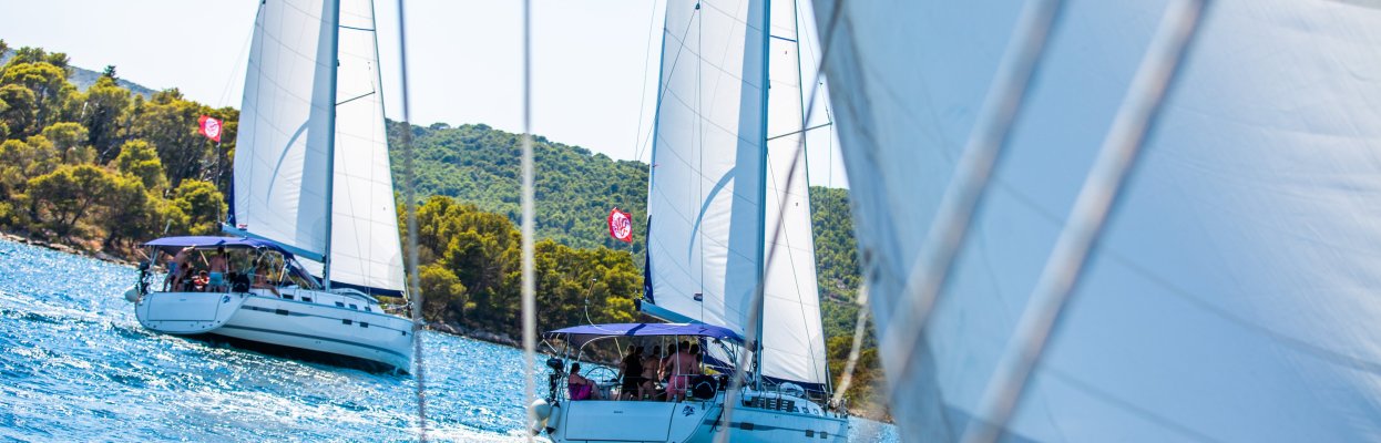 Zeilboten varen op het helderblauwe water voor de Kroatische kust.