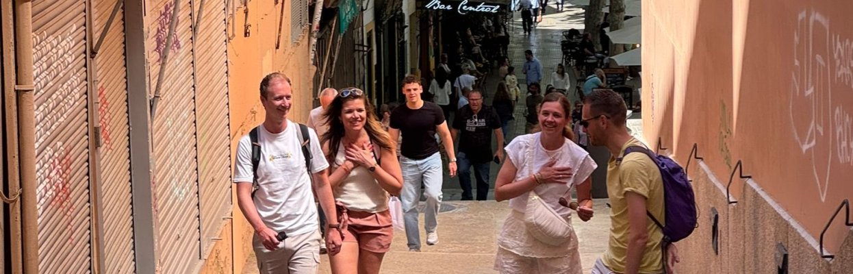 Groepje reisgenoten wandelt door de straten van Mallorca.
