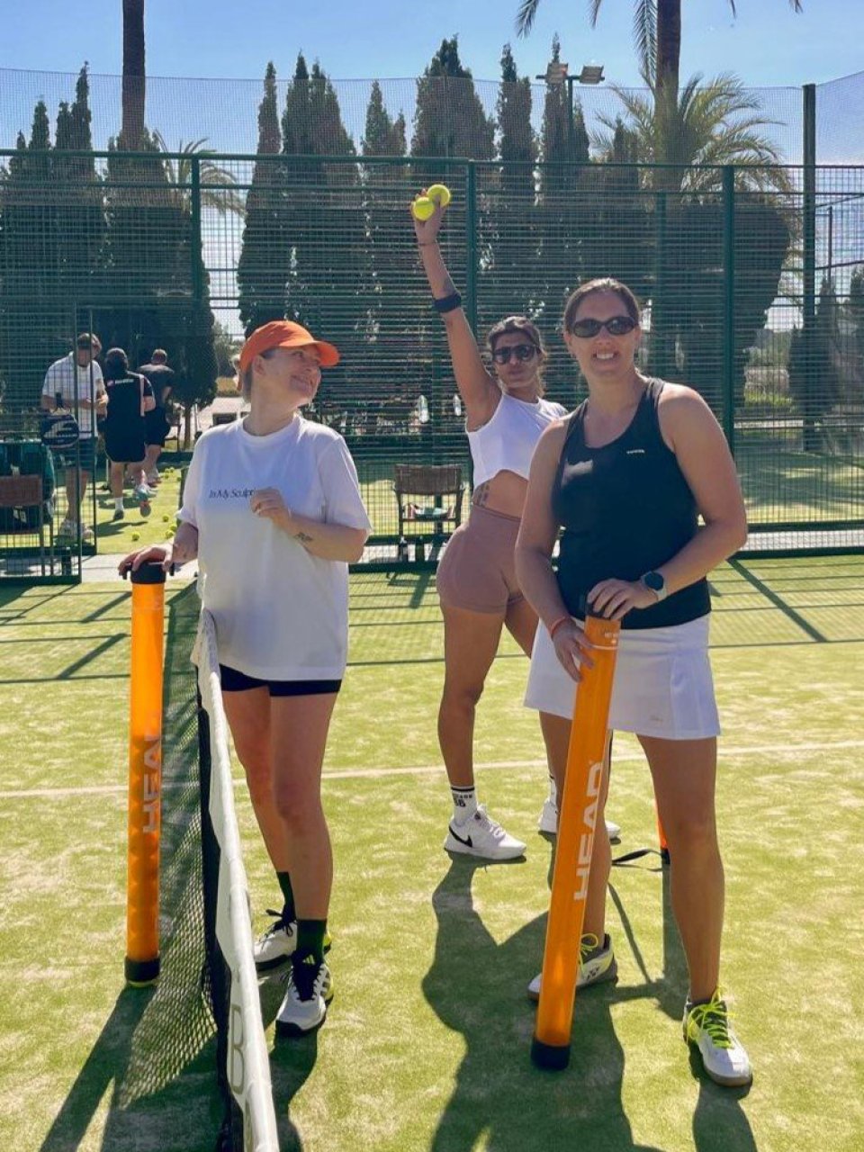 Padellers poseren voor de foto op de padelbaan.