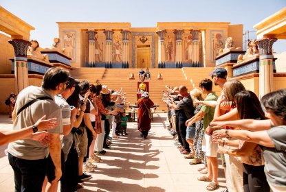 Groep reisgenoten bezoekt samen een kleurrijk Egyptisch tempelcomplex.