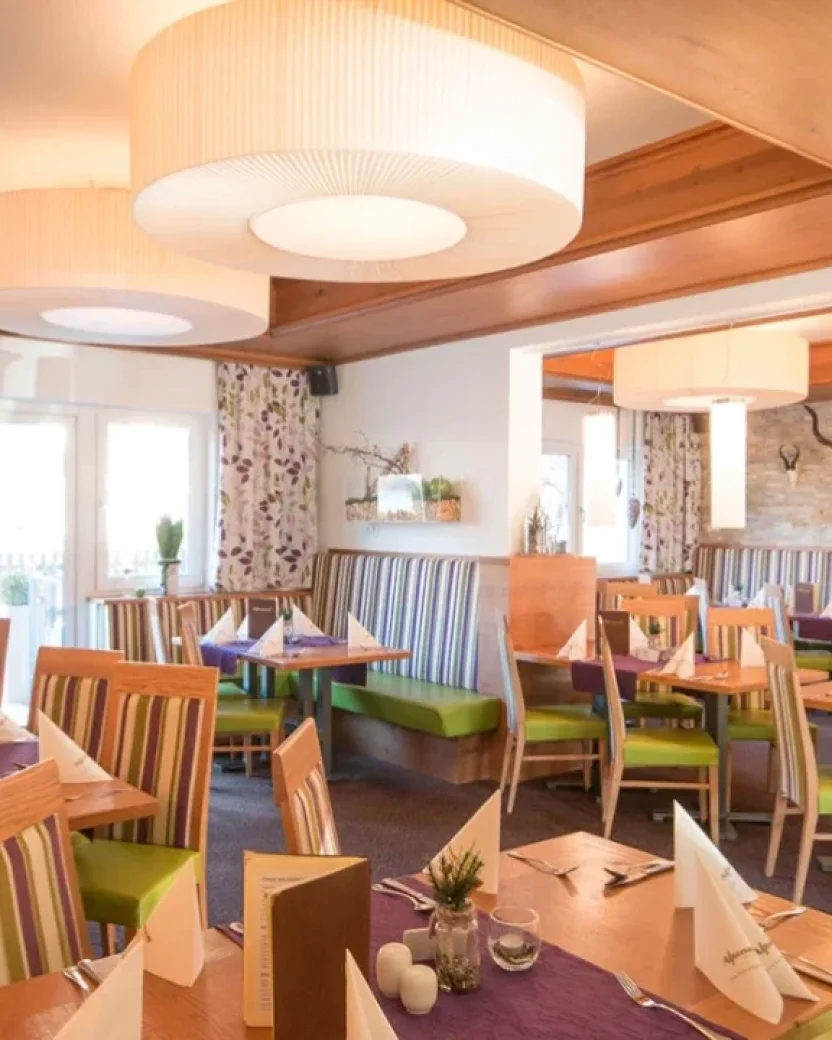 Restaurant van het hotel met gedekte tafels voor ontbijt en diner.