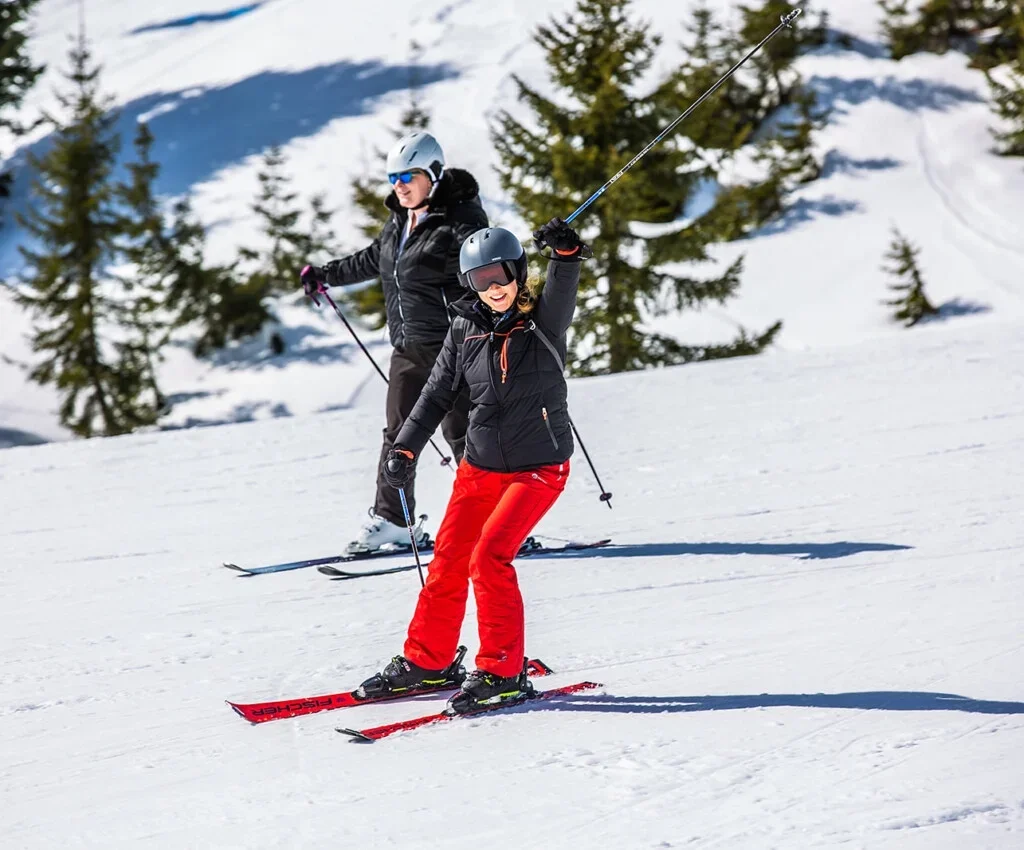 Twee skiërs op een besneeuwde piste in de bergen.