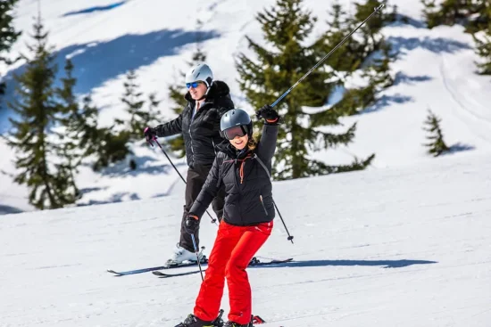 Twee skiërs op een besneeuwde piste in de bergen.