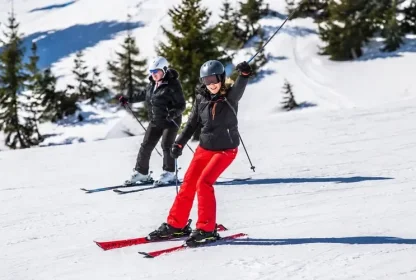 Skiërs maken een afdaling in het wit besneeuwde gebied.