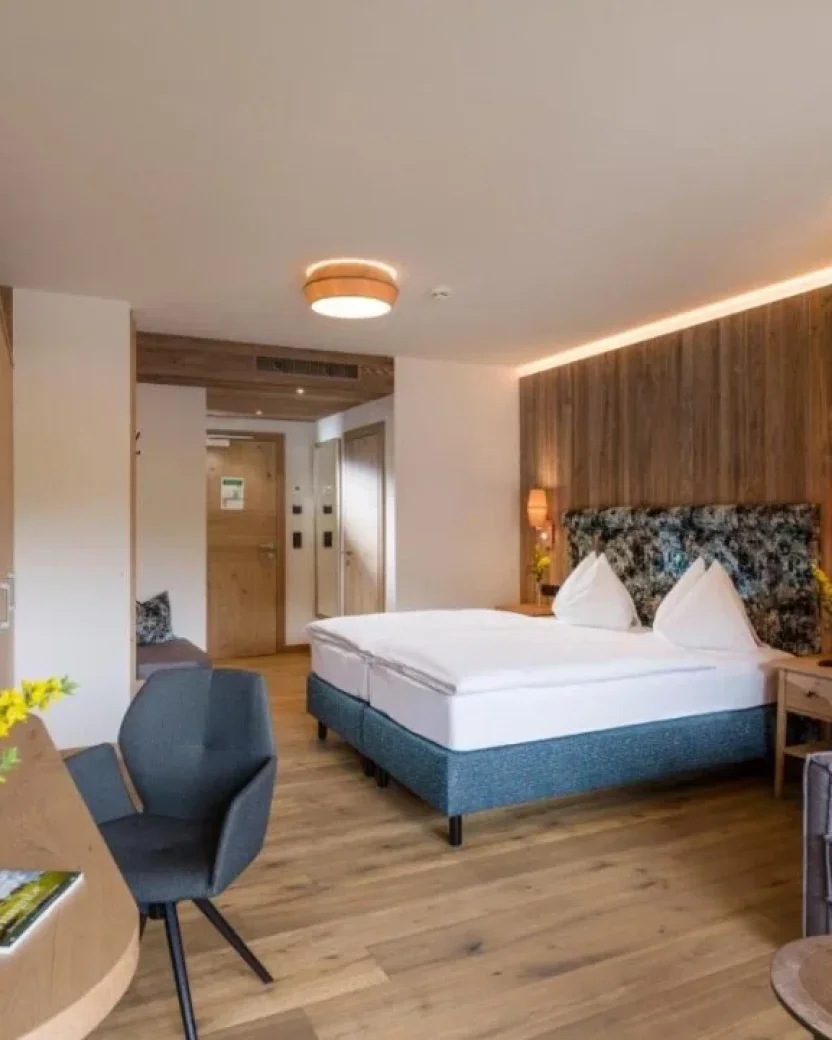 Sfeervolle hotelkamer met aparte bedden en een zithoek.