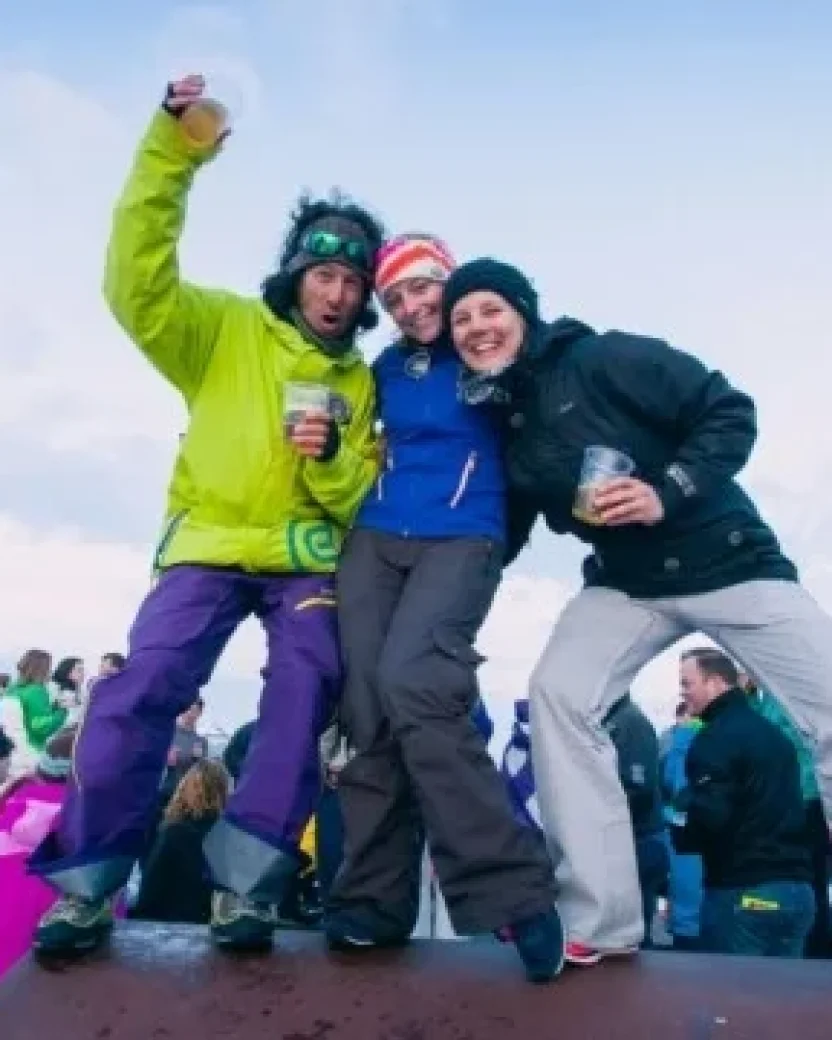 Wintersporters lachen voor de foto tijdens de après-ski.