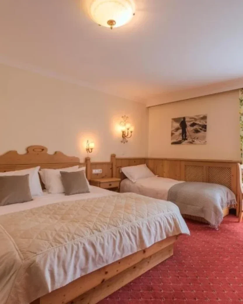 Ruime slaapkamer met twee bedden en zithoek.