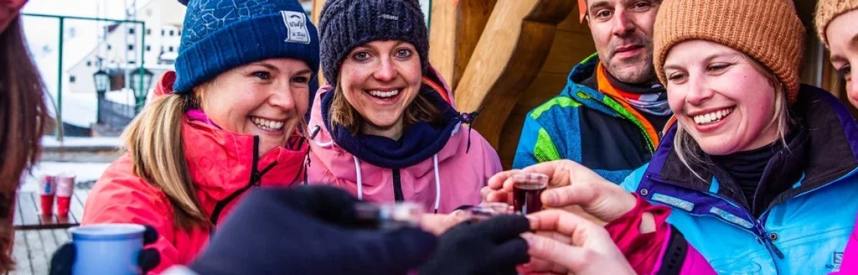 Wintersporters proosten samen met een drankje bij de après-ski.