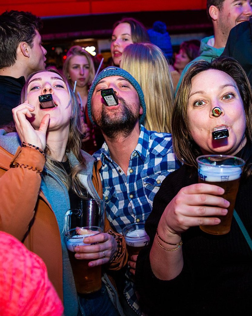 Drie wintersporters drinken samen een biertje tijdens de après-ski.