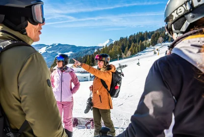 Wintersporters overleggen samen op de piste terwijl één van hen een route aanwijst.