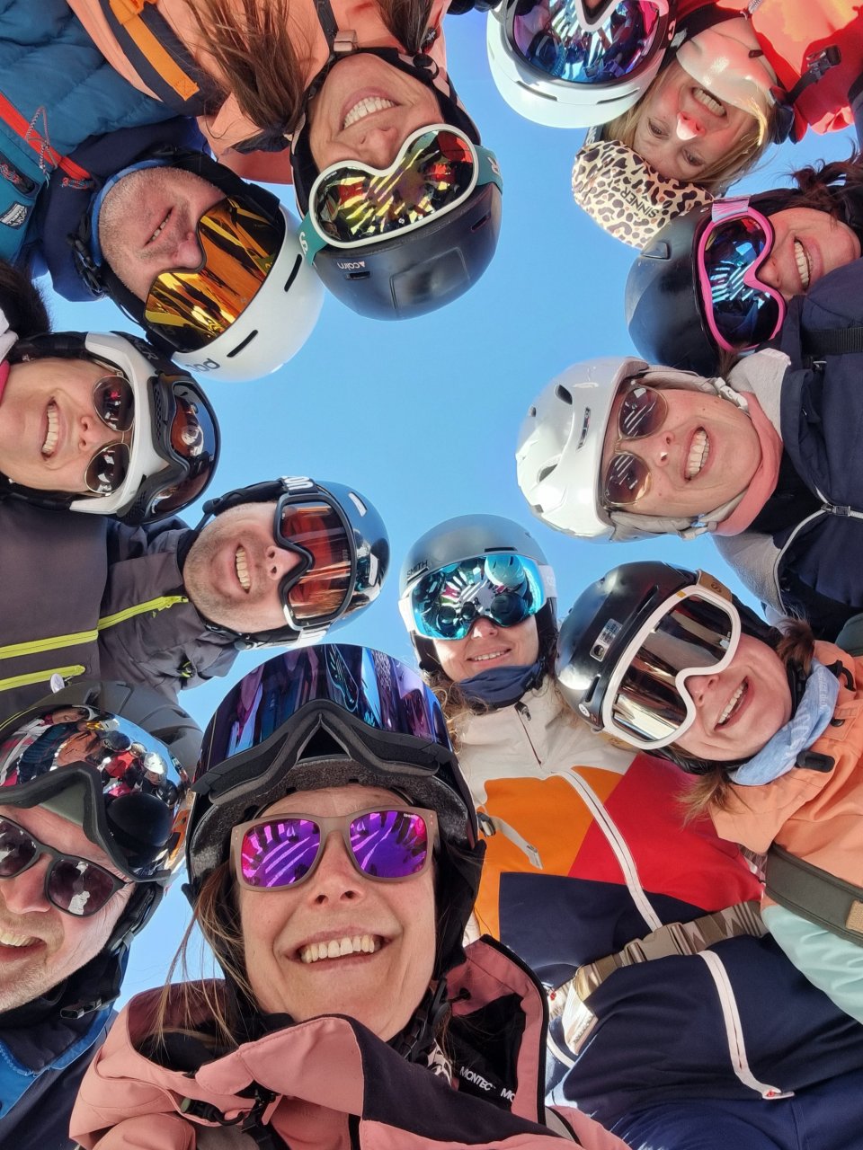 Groep wintersporters maakt samen een vrolijke selfie in de sneeuw.