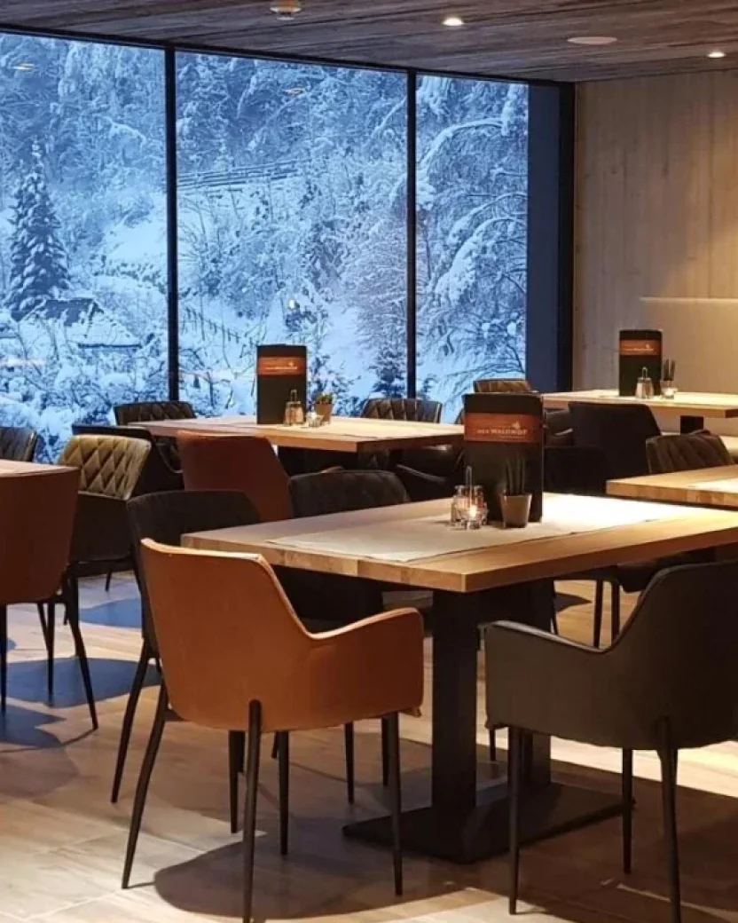 Modern restaurant met uitzicht op de besneeuwde bergen.