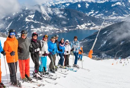 Reisgenoten poseren bovenaan de piste in Zell am See.