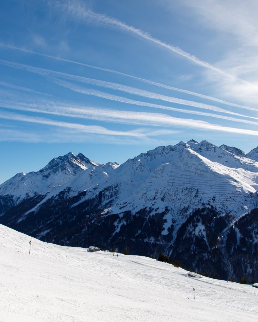 Uitzicht vanaf de besneeuwde piste op de bergen.