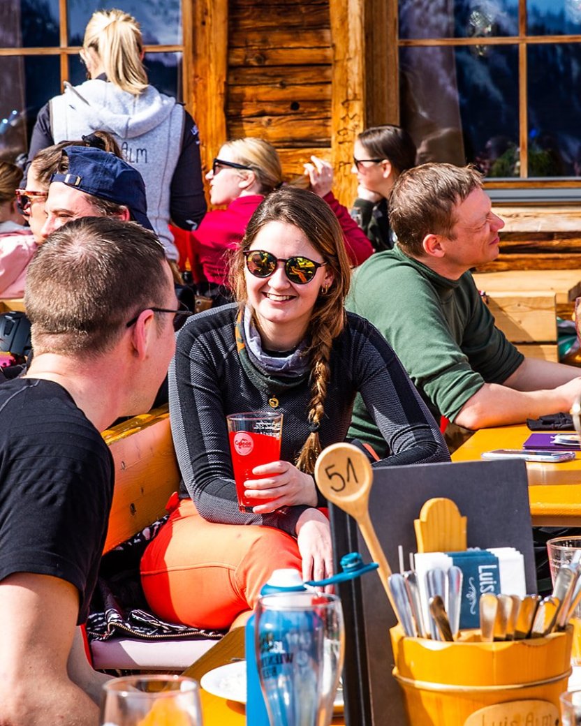Wintersporters genieten van de lunch in de zon op het terras.