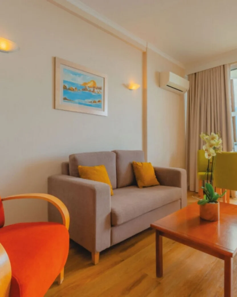Woonkamer met bank, eettafel, airconditioning en balkon.